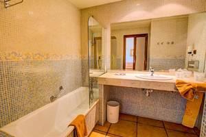 Badezimmer im SBH Club Paraiso Playa Hotel mit Badewanne, Spiegel und Waschbecken.