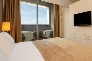 Hotelzimmer mit Bett, Fernseher und Balkon im Crystal Centro Resort.