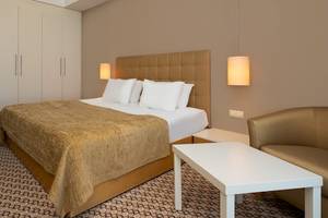 Doppelzimmer im Crystal Centro Resort Hotel mit Bett, Tisch und Sitzbereich.