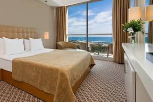 Hotelzimmer im Crystal Centro Resort mit Meerblick, inklusive Bett, Fenster und Balkon.