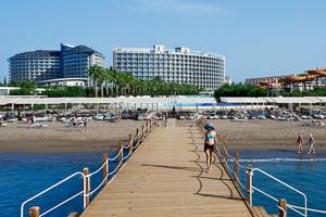 Crystal Centro Resort Strandzugang mit vielen Liegen und Gebäuden im Hintergrund