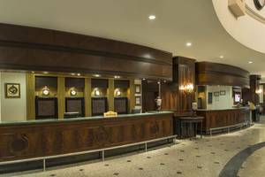 Empfangsbereich des Delphin Palace Hotels mit eleganten Holzmöbeln und Marmorboden.