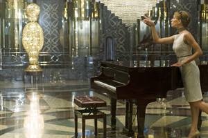 Eine Frau im Delphin Palace Hotel führt ein Klavier in einem luxuriösen Raum.