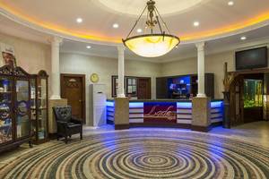Empfangsbereich des Delphin Palace Hotels mit großem Kronleuchter und modernem Design.