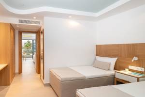 Innenansicht eines Zimmers im Lyttos Mare Hotel mit zwei Betten und modernem Interieur.