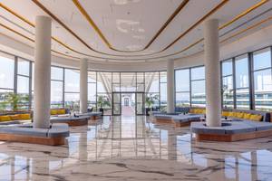 Lobby des Lyttos Mare Hotels mit Marmorboden und großen Fenstern zum Meer.