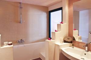 Badezimmer im Veggera Hotel mit Badewanne, Waschbecken und Kosmetikartikeln.