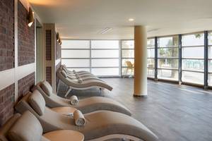 Innenansicht des Entspannungsbereichs des Duja Bodrum Hotels mit mehreren Liegen und Glaswänden.
