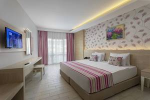 Hotelzimmer im Duja Bodrum mit Fernseher, Bett, Schreibtisch und Stuhl.