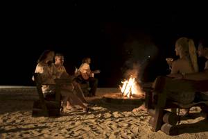 Gruppe von Gästen genießt ein Abendfeuer am Strand des Maritim Resort & Spa Mauritius