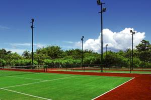 Tennisplatz im Maritim Resort & Spa Mauritius mit grünem und rotem Belag, umgeben von Bäumen.