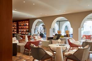 Loungebereich im MarBella Corfu Hotel mit Möbeln und Bücherregalen.