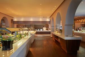 Das Innendesign des Speisesaals im MarBella Corfu Hotel mit Buffets und einem Angestellten.