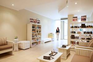 Loungebereich des MarBella Corfu Hotels mit Sitzmöbeln, Tischen und Regalen.