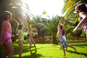 Kinder spielen im Garten des MarBella Corfu Hotels mit einem Ball.