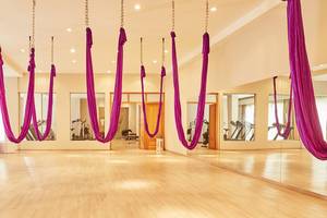 Yoga-Studio im MarBella Corfu Hotel mit hängenden Yoga-Seiden und Fitnessgeräten.