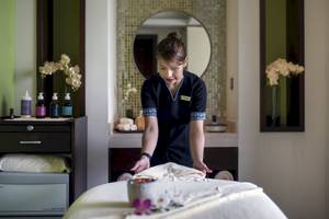 Eine Angestellte im Khalidiya Palace Rayhaan bereitet eine Massageliege vor.