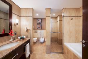 Badezimmer im Khalidiya Palace Rayhaan by Rotana Hotel mit Badewanne, Dusche und Toilette.