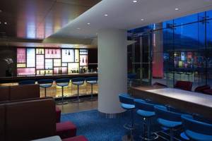 Innenansicht der Bar im Park Plaza County Hall London Hotel mit blauen Stühlen und einem langen Tisch.