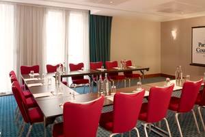 Konferenzraum im Park Plaza County Hall London mit roten Stühlen und Tischen.