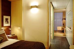Schlafzimmer im Park Plaza County Hall London Hotel mit Bett, Kissen und Nachttisch