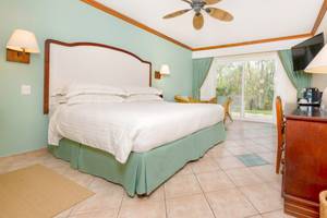 Ein Schlafzimmer im Occidental Tamarindo Hotel mit einem großen Bett, einer Klimaanlage und einem offenen Balkon.
