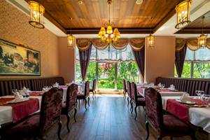 Innenansicht des Restaurants im Vita Silva Hotel mit gepolsterten Bänken, gedeckten Tischen und großen Fenstern.