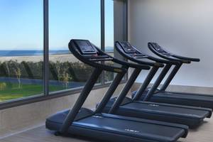 Fitnessstudio im Steigenberger Resort Ras Soma mit Blick auf das Meer und drei schwarzen Laufbändern