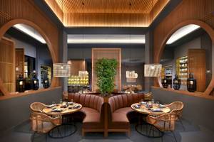 Das Interieur des Hotels 'Steigenberger Resort Ras Soma' zeigt ein Restaurant mit braunen Ledersofas, runden Tischen, hängenden Lampen und einer zentralen Pflanze.