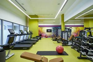 Fitnesscenter im Riu Dubai Hotel mit Laufbändern, Hanteln und einer roten Yoga-Kugel.
