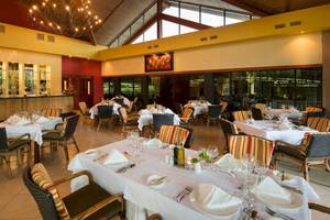 Innenansicht des Restaurants im Occidental Tamarindo Hotel mit eingerichteten Tischen und Stühlen.