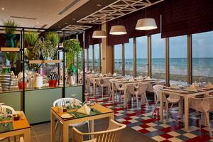 Innenansicht des Restaurants im Riu Dubai Hotel mit Blick auf das Meer.