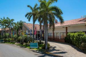 Eingangsbereich des Occidental Tamarindo Hotels mit Palmen und verschiedenen Flaggen