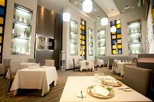 Innenansicht des Kulinarium Restaurants mit Tisch, Teller, Gläsern und Hockern.