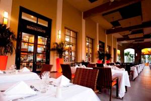Innenansicht des Montecristo Restaurants im Riu Palace Bavaro Hotel mit gedeckten Tischen und Stühlen.