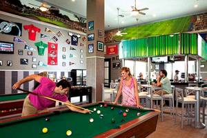 Poolhalle im Riu Palace Bavaro mit zwei Spieltischen, Gästen, die Billard spielen, und dekorativen Wänden.