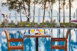 Frühstückstisch am Pool des Louis Kerkyra Blue Hotels mit Blick auf das Meer.