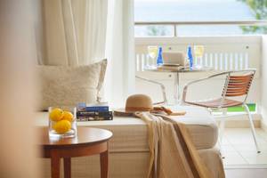 Balkonblick des Louis Kerkyra Blue Hotels mit Möbeln und Büchern.