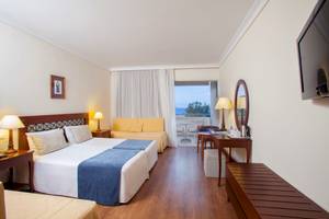 Doppelzimmer im Louis Kerkyra Blue Hotel mit Meerblick, zwei Betten, Sofa und Schreibtisch.