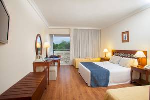 Innenansicht eines Hotelzimmers im Louis Kerkyra Blue mit zwei Betten, Schreibtisch und Balkon.