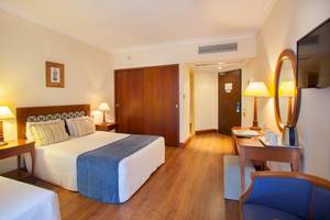 Hotelzimmer des Louis Kerkyra Blue mit Doppelbett, Nachttischen und Schreibtisch.