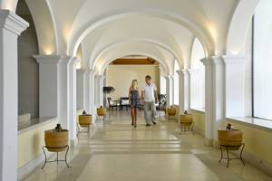 Ein Paar geht durch die geflieste Halle des Louis Kerkyra Blue Hotels.