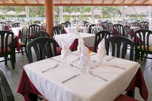 Innenansicht des Restaurants im Occidental Tamarindo Hotel mit gedeckten Tischen und Stühlen.