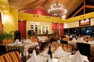 Innenansicht des Restaurants im Occidental Tamarindo Hotel mit gekleideten Tischen und einer großen Kristallleuchte.