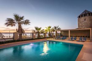 Außenpool des Mitsis La Vita Beach Hotels am Abend mit blauem Wasser und Liegen