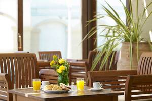 Frühstückstisch im Mitsis La Vita Beach Hotel mit Orangensaft, Croissants und Brot.