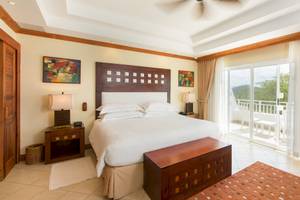 Schlafzimmer im Occidental Tamarindo Hotel mit Bett, Nachttischen und Zugang zur Terrasse.