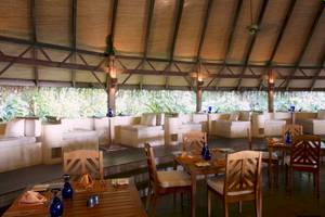 Innenbereich des Coco Palm Dhuni Kolhu Hotels mit Sitzbereichen und Tischen