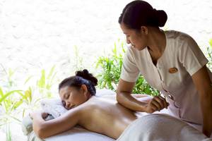 Eine Frau genießt eine Massagebehandlung im Coco Palm Dhuni Kolhu.