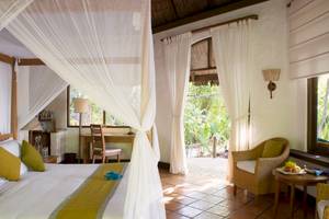Schlafzimmer im Coco Palm Dhuni Kolhu Hotel mit Bett, Schreibtisch und Fenstern